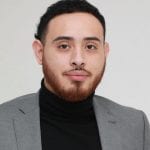A man in a suit and black shirt
